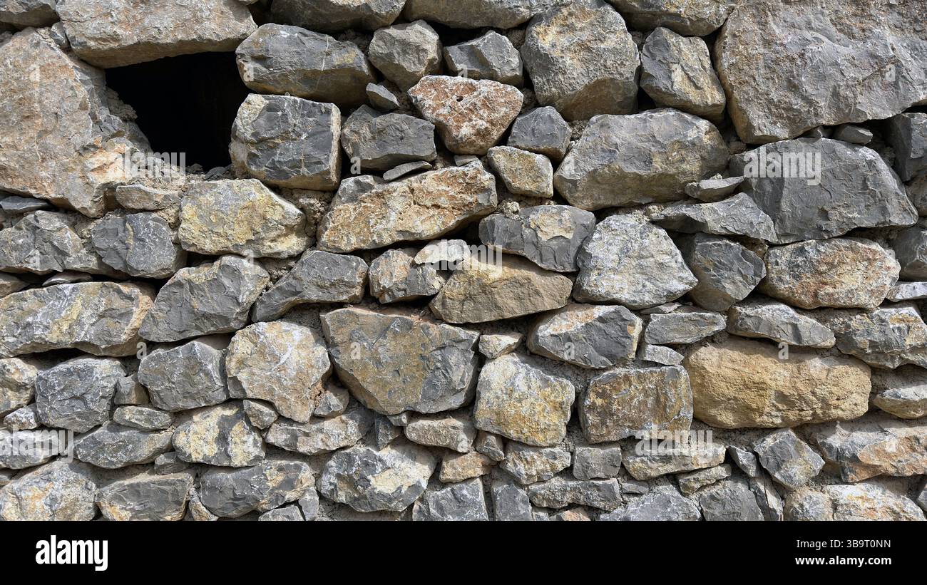 Natursteinmauer aus großen Steinen Stockfoto