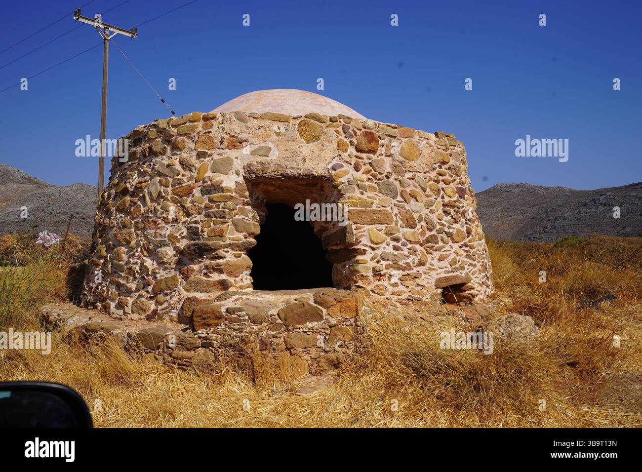 Ein traditioneller Holzkohleofen aus Stein, der für die Produktion von Holzkohle durch kontrollierte Holzfeuerungsstände in einer abgelegenen Ricaleinstellung verwendet wird Stockfoto