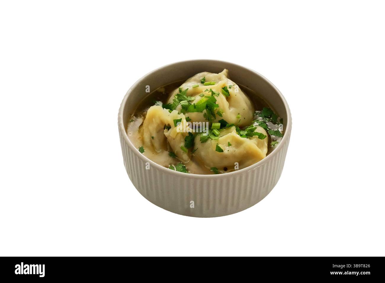 Manti (Manti oder Manty) in dicker Fleischsoße mit Kräutern in einer weißen Schüssel. Ein zentralasiatisches Gericht. Stockfoto