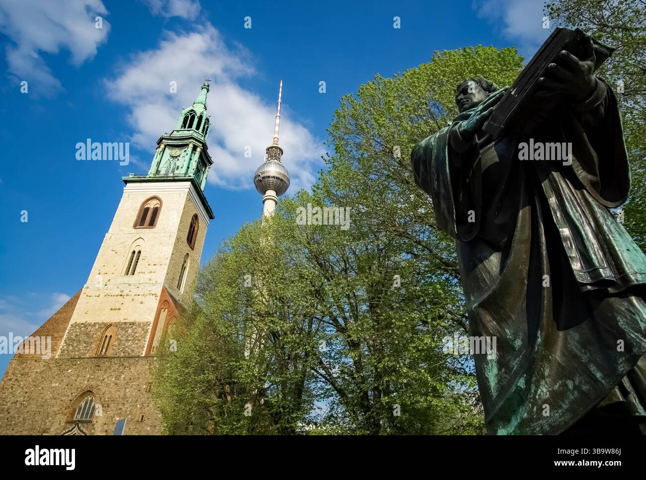 Statue von Martin Luther vor der Marienkirche und dem berühmten Berliner Fernsehturm am Alexanderplatz, Berlin Mitte. Stockfoto