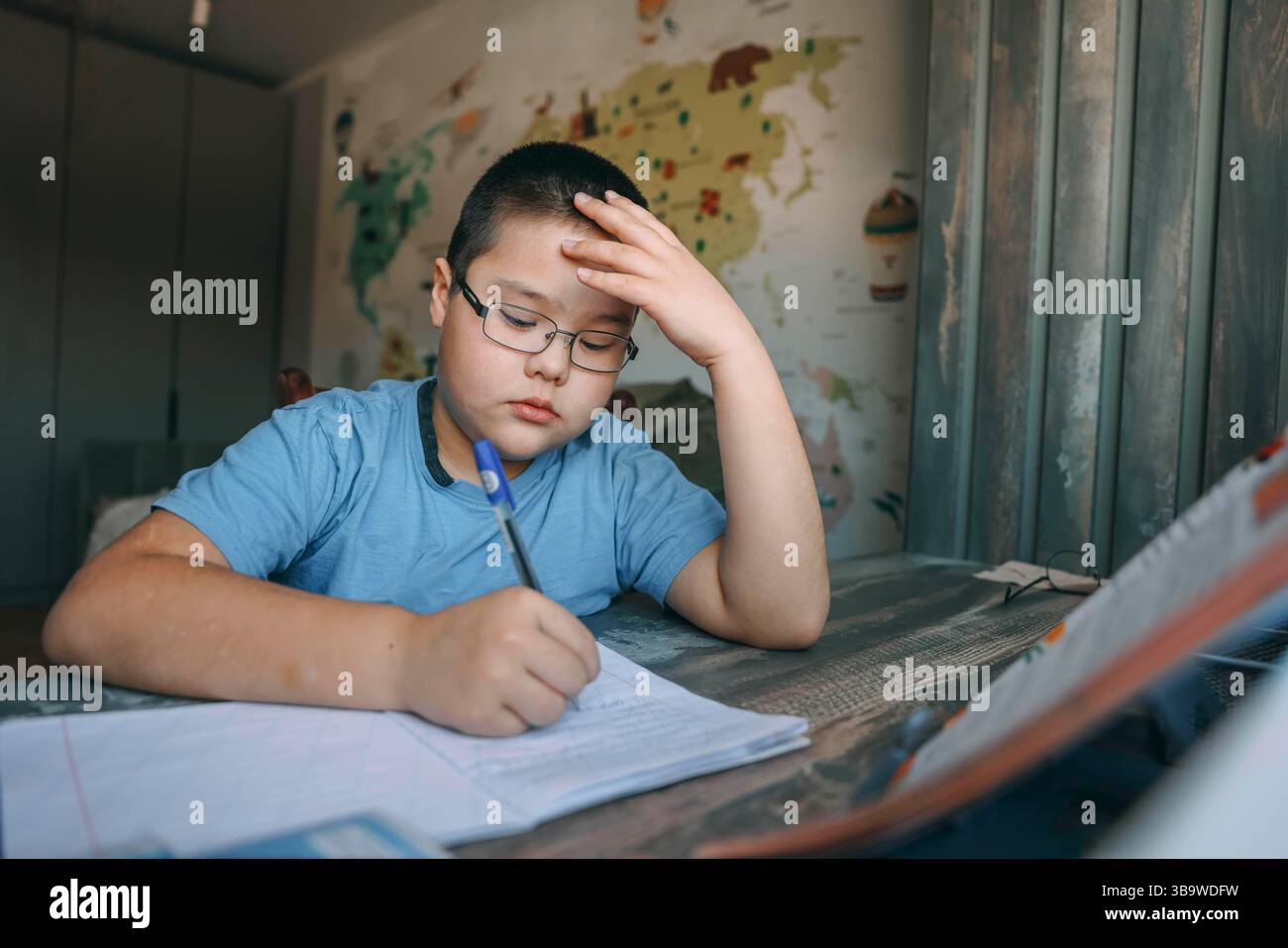 asiatischer Junge mit einer Brille, die frustriert den Kopf hält, Schulaufgabe am Schreibtisch in der Nähe der Welt, Landkarte, Konzept der Hausschulung, Bildungsdienst Stockfoto