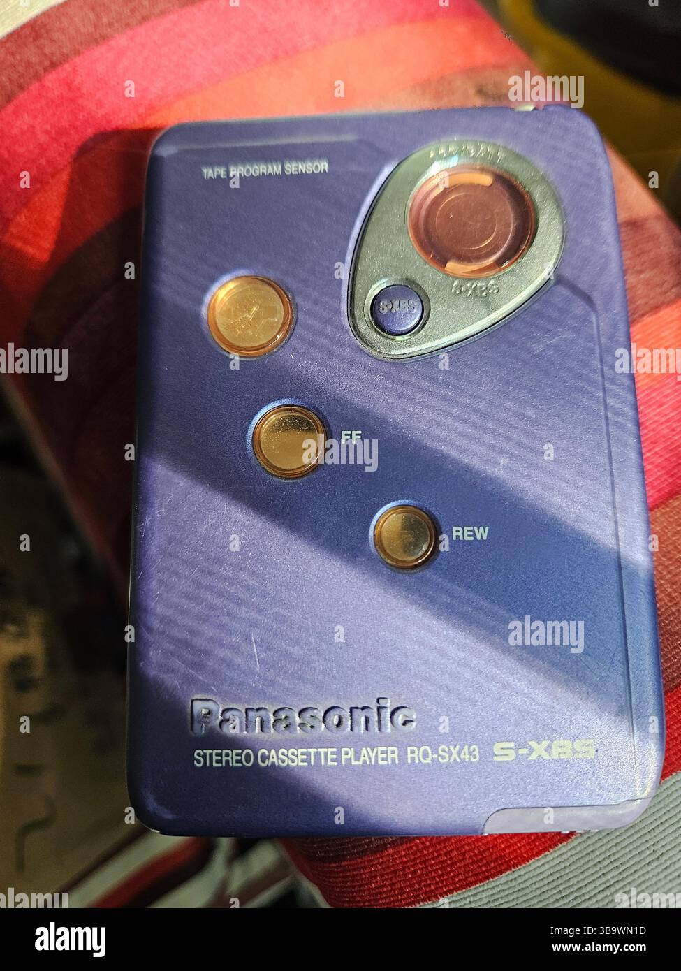 Nahaufnahme des Panasonic RQ-SX43 Stereo-Kassettenspielers mit Retro-Design auf farbenfrohem Stoffhintergrund Stockfoto