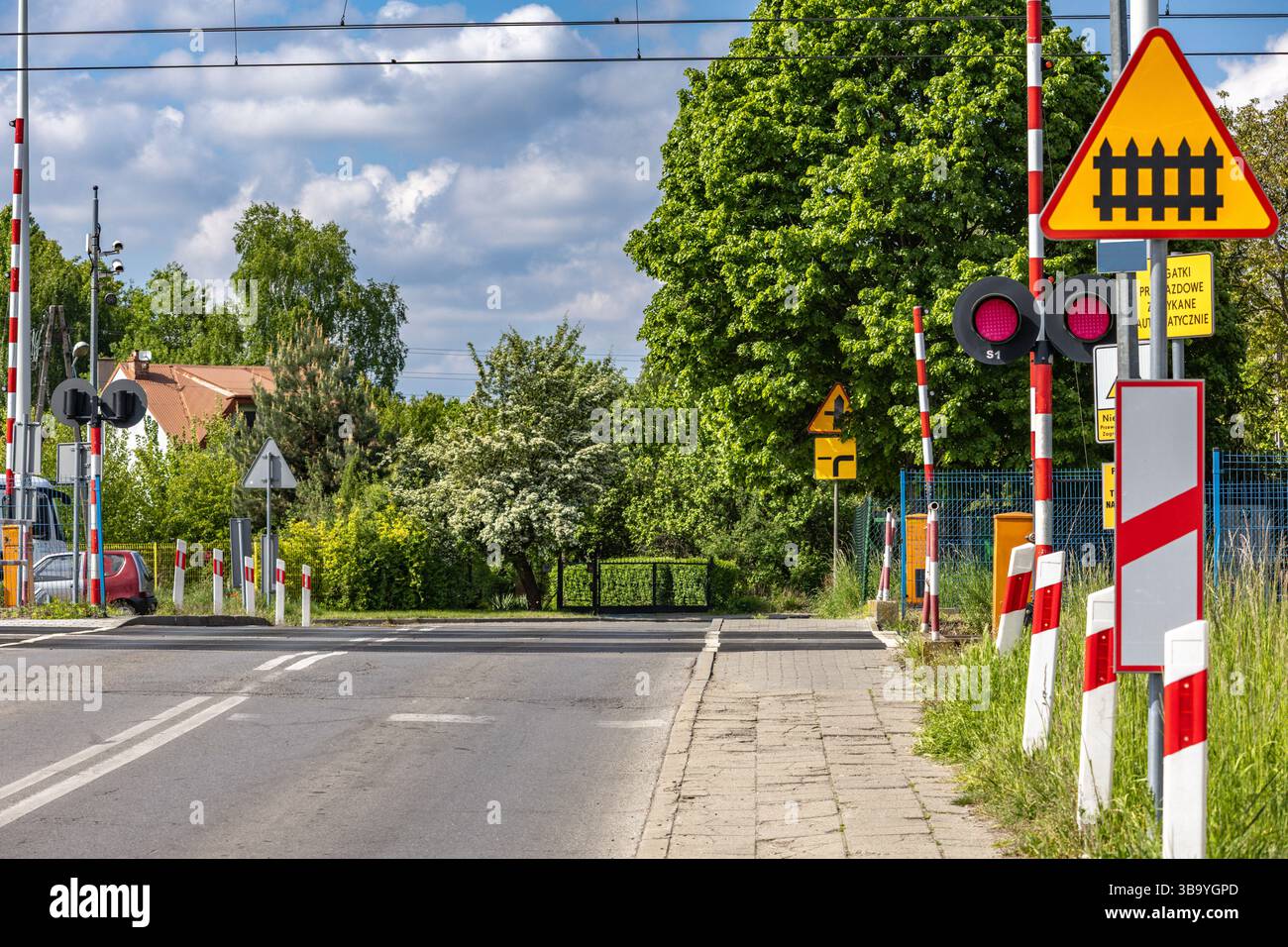 Autos passieren einen Bahnübergang mit roter Ampel, beschädigte Bahnbarrieren am Übergang, Verkehrsverletzung Stockfoto
