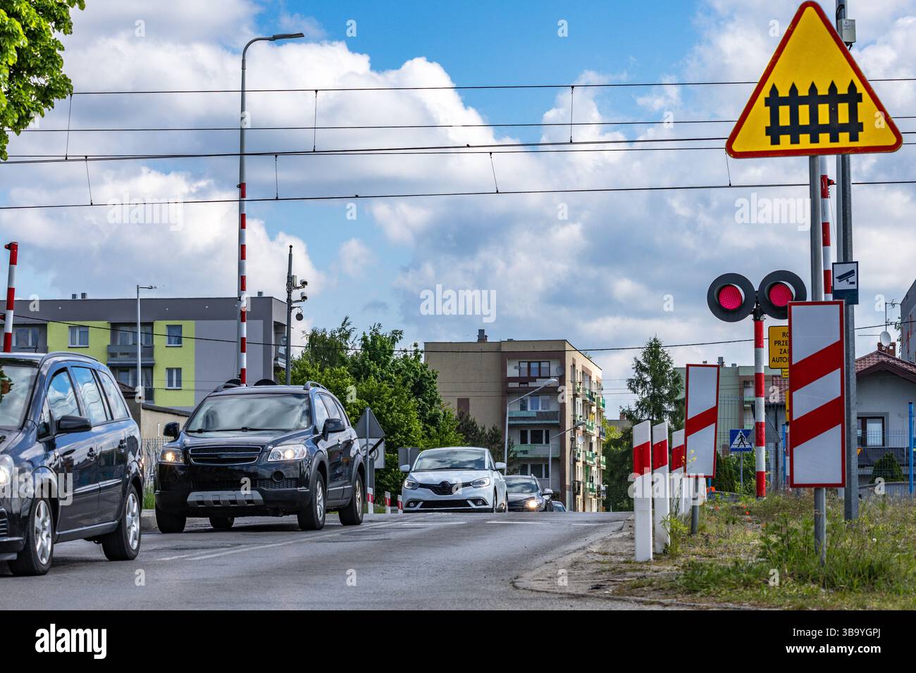 Autos passieren einen Bahnübergang mit roter Ampel, beschädigte Bahnbarrieren am Übergang, Verkehrsverletzung Stockfoto