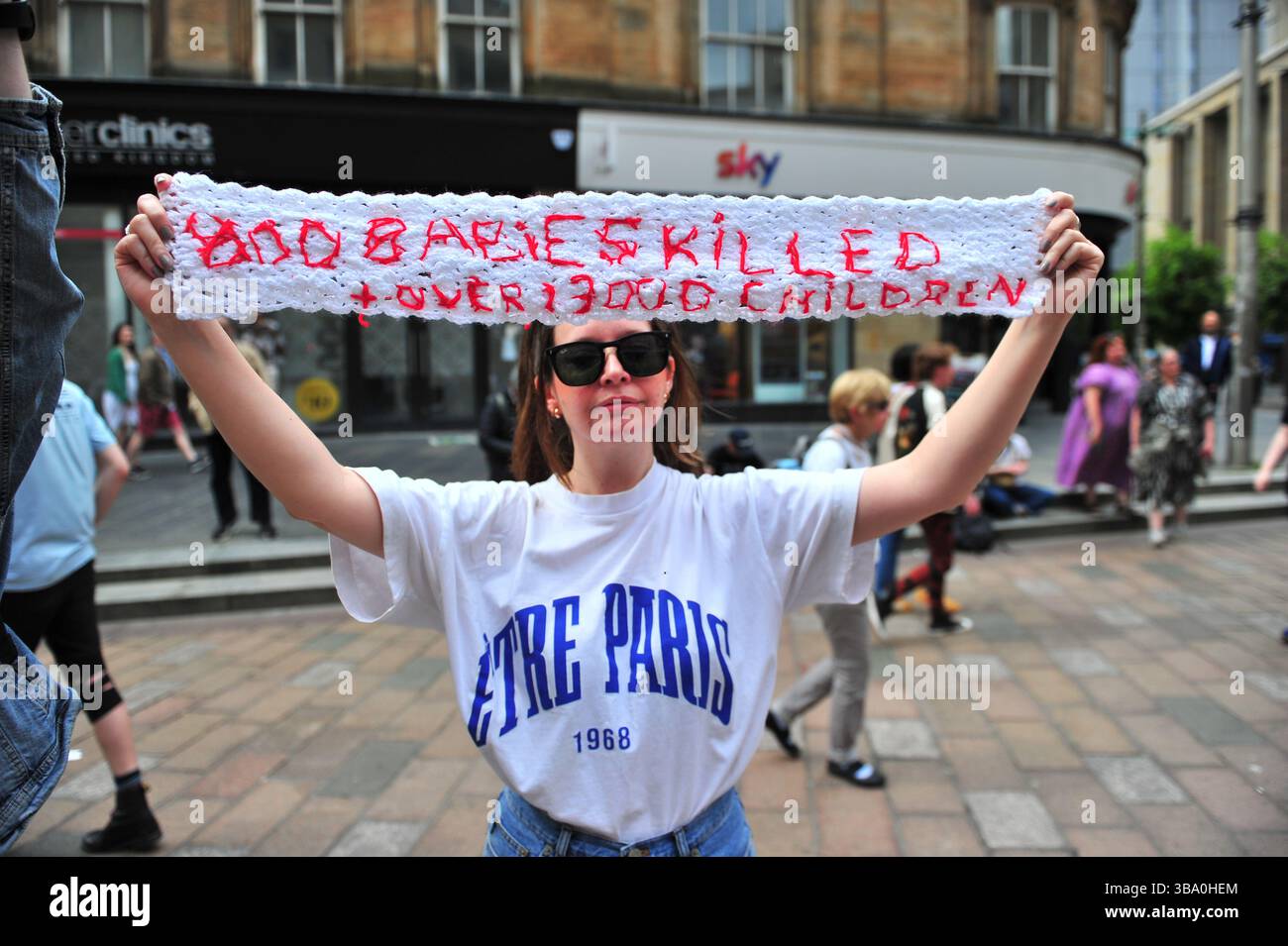 Glasgow, Großbritannien. 11. Mai 2025: Während einer Rede eines Demonstranten, kurz nachdem er von der Polizei Schottland freigelassen wurde, wird ein gestricktes Banner in der Hand gesehen. Demonstranten versammelten sich vor den Stufen in der Buchannan Street, um gegen rechtsextreme Gruppen zu protestieren, die Israel unterstützen. Quelle: Eastern Goodwin Media/Alamy Live News Stockfoto