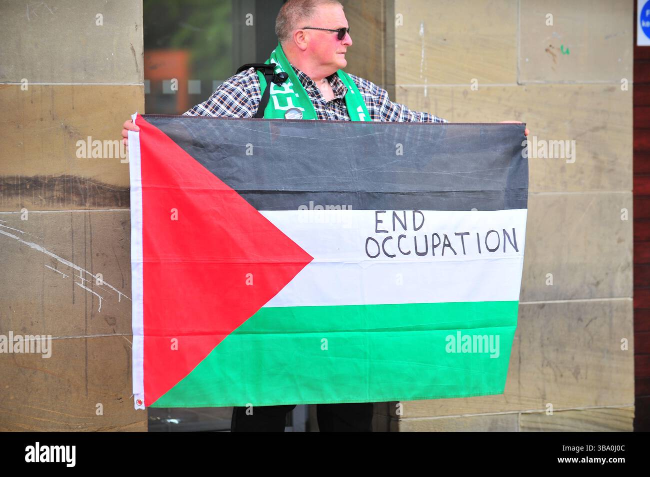 Glasgow, Großbritannien. 11. Mai 2025: Demonstranten halten am Haupteingang des Hotels, in dem die Veranstaltung stattfand, die Flagge von Palästina mit DER Aufschrift „ENDE DER BESATZUNG“. Demonstranten versammelten sich vor den Stufen in der Buchannan Street, um gegen rechtsextreme Gruppen zu protestieren, die Israel unterstützen. Quelle: Eastern Goodwin Media/Alamy Live News Stockfoto
