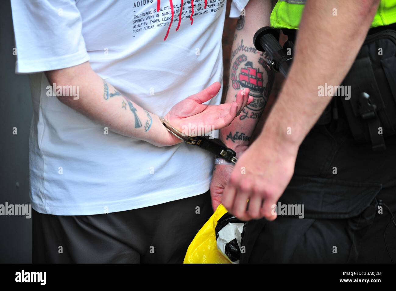 Glasgow, Großbritannien. 11. Mai 2025 - Nahaufnahme des Mannes in Handschellen, als er während der Proteste von der Polizei Schottland verhaftet wird. Demonstranten versammelten sich vor den Stufen in der Buchannan Street, um gegen rechtsextreme Gruppen zu protestieren, die Israel unterstützen. Quelle: Eastern Goodwin Media/Alamy Live News Stockfoto