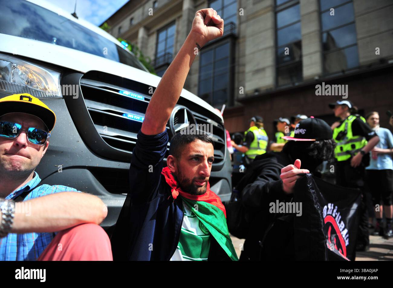 Glasgow, Großbritannien. 11. Mai 2025 - Ein Demonstrant wird während des Protestes mit erhobener Faust in der Luft gesehen, während er einen Polizeiwagen blockiert, nachdem er einen Demonstranten verhaftet hat. Demonstranten versammelten sich vor den Stufen in der Buchannan Street, um gegen rechtsextreme Gruppen zu protestieren, die Israel unterstützen. Quelle: Eastern Goodwin Media/Alamy Live News Stockfoto