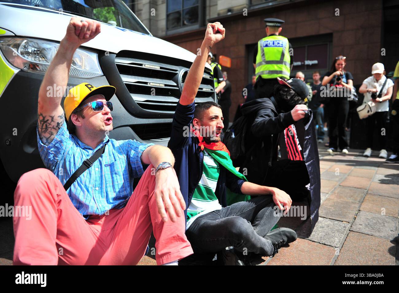 Glasgow, Großbritannien. 11. Mai 2025 - Demonstranten werden während des Protestes mit erhobenen Fäusten in der Luft gesehen, während sie einen Polizeiwagen blockieren, nachdem sie einen Demonstranten verhaftet haben. Demonstranten versammelten sich vor den Stufen in der Buchannan Street, um gegen rechtsextreme Gruppen zu protestieren, die Israel unterstützen. Quelle: Eastern Goodwin Media/Alamy Live News Stockfoto