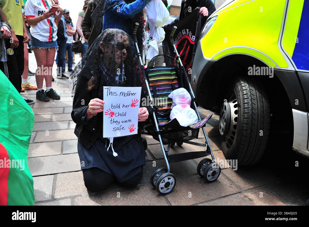 Glasgow, Großbritannien. 11. Mai 2025 - Ein Demonstrant wird in Schwarz mit einem Scheinkind in einem Kinderwagen gesehen, während er ein Plakat hält, während Demonstranten den Polizeiwagen blockieren, nachdem sie einen Demonstranten verhaftet haben. Demonstranten versammelten sich vor den Stufen in der Buchannan Street, um gegen rechtsextreme Gruppen zu protestieren, die Israel unterstützen. Quelle: Eastern Goodwin Media/Alamy Live News Stockfoto