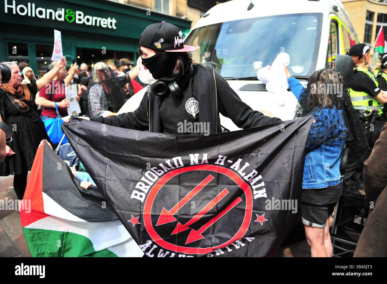 Glasgow, Großbritannien. 11. Mai 2025 - Ein Demonstrant wird während des Protestes mit seiner Flagge gesehen, während er einen Polizeiwagen blockiert, nachdem er einen Demonstranten verhaftet hat. Demonstranten versammelten sich vor den Stufen in der Buchannan Street, um gegen rechtsextreme Gruppen zu protestieren, die Israel unterstützen. Quelle: Eastern Goodwin Media/Alamy Live News Stockfoto