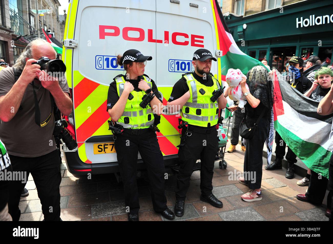Glasgow, Großbritannien. 11. Mai 2025: Polizeibeamte stehen auf der Rückseite des Lieferwagens, während Demonstranten ihn nach einer Verhaftung umzingelten. Demonstranten versammelten sich vor den Stufen in der Buchannan Street, um gegen rechtsextreme Gruppen zu protestieren, die Israel unterstützen. Quelle: Eastern Goodwin Media/Alamy Live News Stockfoto
