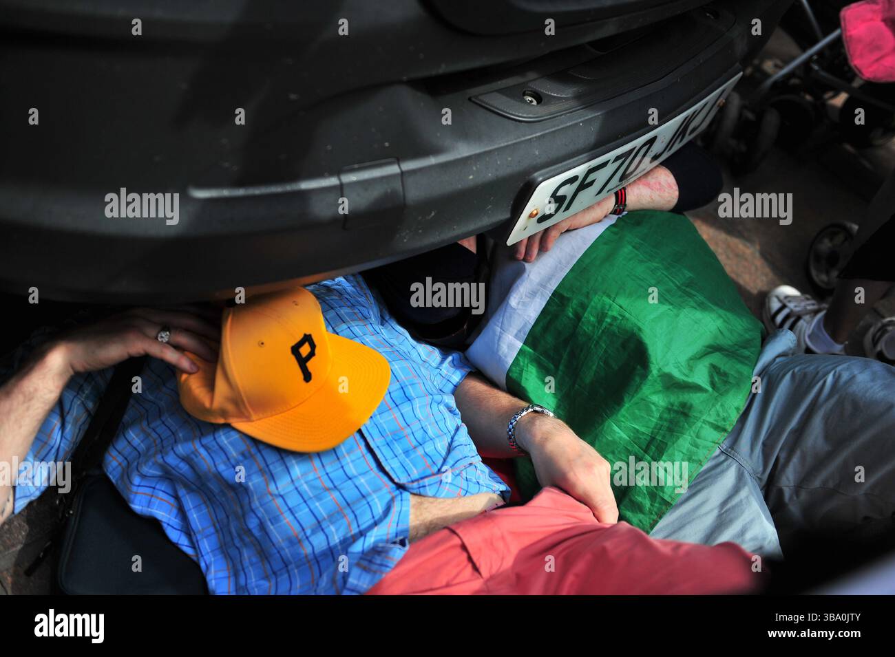 Glasgow, Großbritannien. 11. Mai 2025: Zwei Demonstranten keilen sich unter den Van, um ihn davon abzuhalten. Demonstranten versammelten sich vor den Stufen in der Buchannan Street, um gegen rechtsextreme Gruppen zu protestieren, die Israel unterstützen. Quelle: Eastern Goodwin Media/Alamy Live News Stockfoto