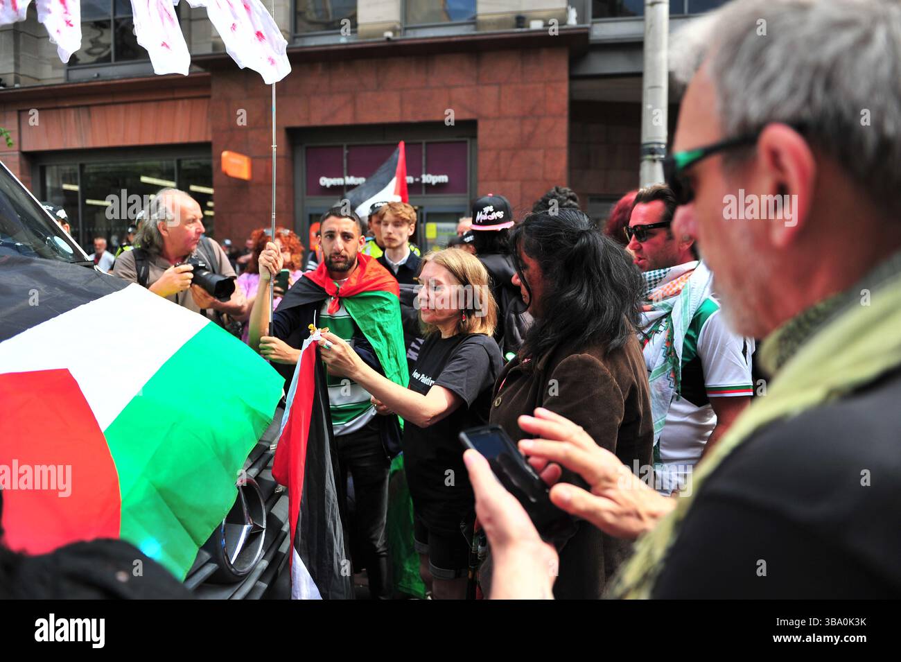 Glasgow, Großbritannien. 11. Mai 2025 - Ein Demonstrant wird gesehen, wie er mehrere Flaggen an der Vorderseite des Van angebracht hat. Demonstranten versammelten sich vor den Stufen in der Buchannan Street, um gegen rechtsextreme Gruppen zu protestieren, die Israel unterstützen. Quelle: Eastern Goodwin Media/Alamy Live News Stockfoto