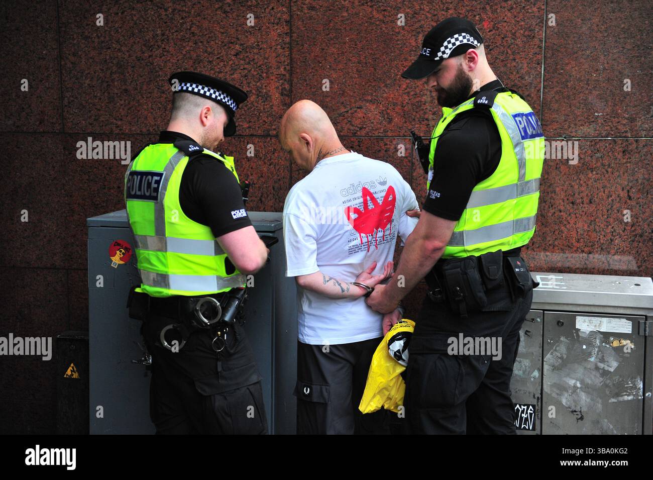 Glasgow, Großbritannien. 11. Mai 2025 - Ein Mann wird in Handschellen gesehen, nachdem er von der Polizei Schottland bei der Proteste verhaftet wurde. Demonstranten versammelten sich vor den Stufen in der Buchannan Street, um gegen rechtsextreme Gruppen zu protestieren, die Israel unterstützen. Quelle: Eastern Goodwin Media/Alamy Live News Stockfoto