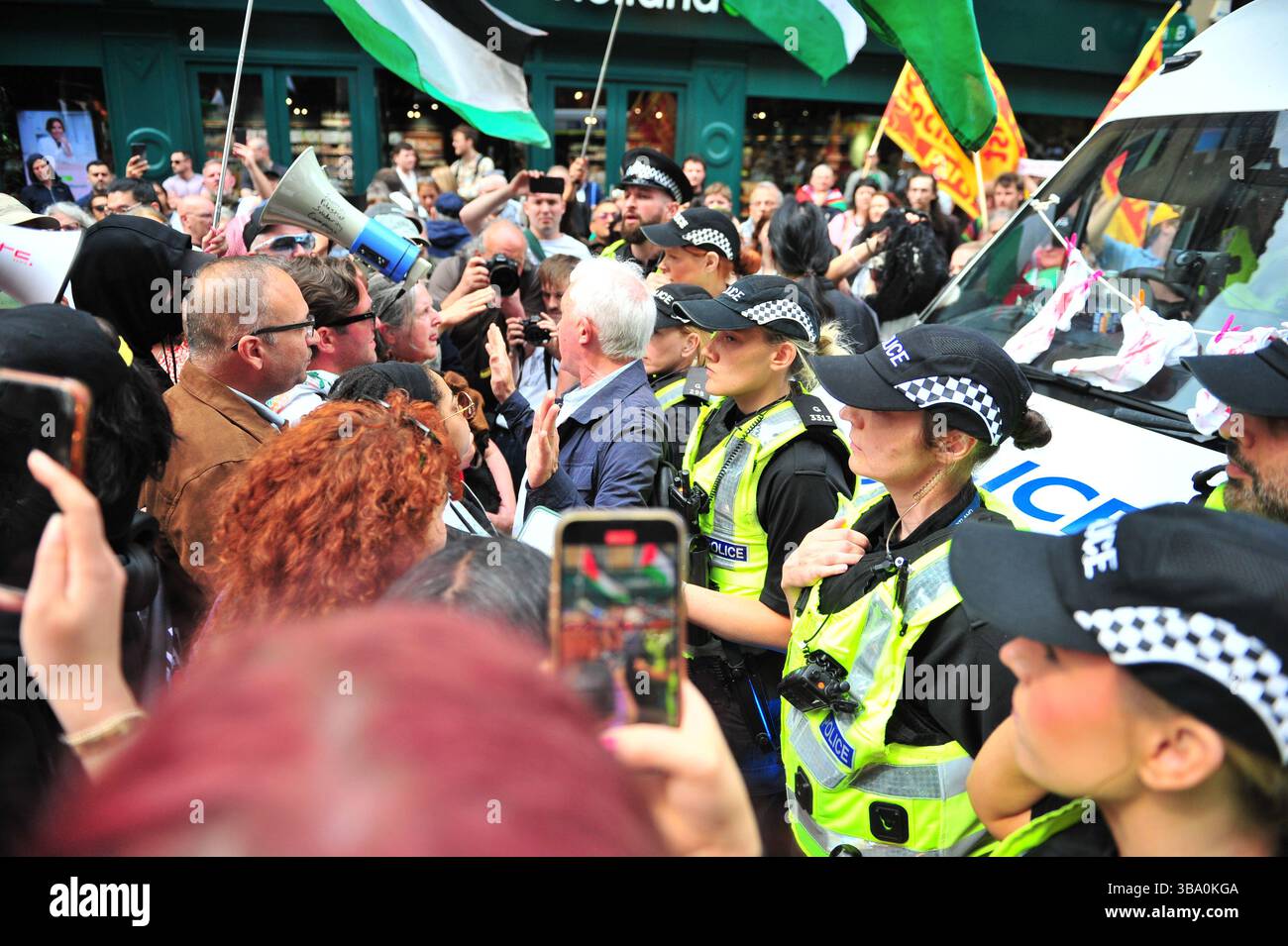 Glasgow, Großbritannien. 11. Mai 2025: Ein Demonstrant wird zwischen Demonstranten und Polizei gesehen, während er versucht, für die Freilassung der Demonstranten zu arbeiten. Demonstranten versammelten sich vor den Stufen in der Buchannan Street, um gegen rechtsextreme Gruppen zu protestieren, die Israel unterstützen. Quelle: Eastern Goodwin Media/Alamy Live News Stockfoto