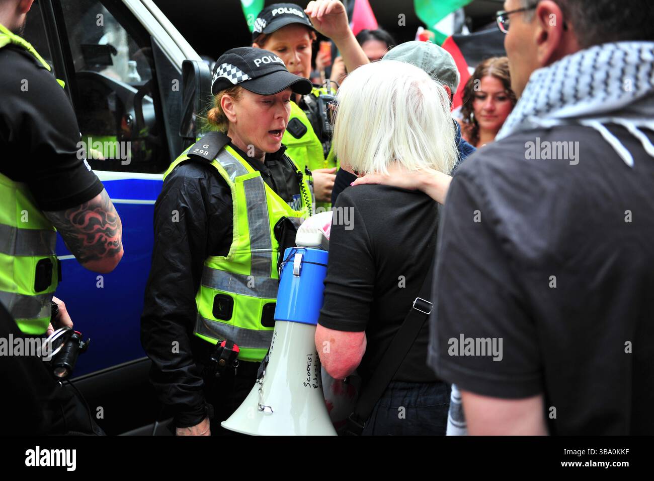 Glasgow, Großbritannien. 11. Mai 2025 - Ein Demonstrant und ein Polizist werden in einem geheizten Austausch über kaputtes Eigentum der Frau gesehen. Demonstranten versammelten sich vor den Stufen in der Buchannan Street, um gegen rechtsextreme Gruppen zu protestieren, die Israel unterstützen. Quelle: Eastern Goodwin Media/Alamy Live News Stockfoto