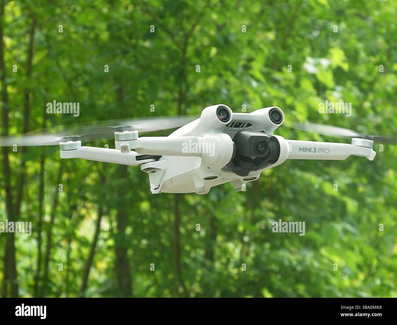Drohne DJI Mini3 Pro - ferngesteuerter Quadcopter - im Flug auf grünem Naturhintergrund, Bayern, Deutschland Stockfoto