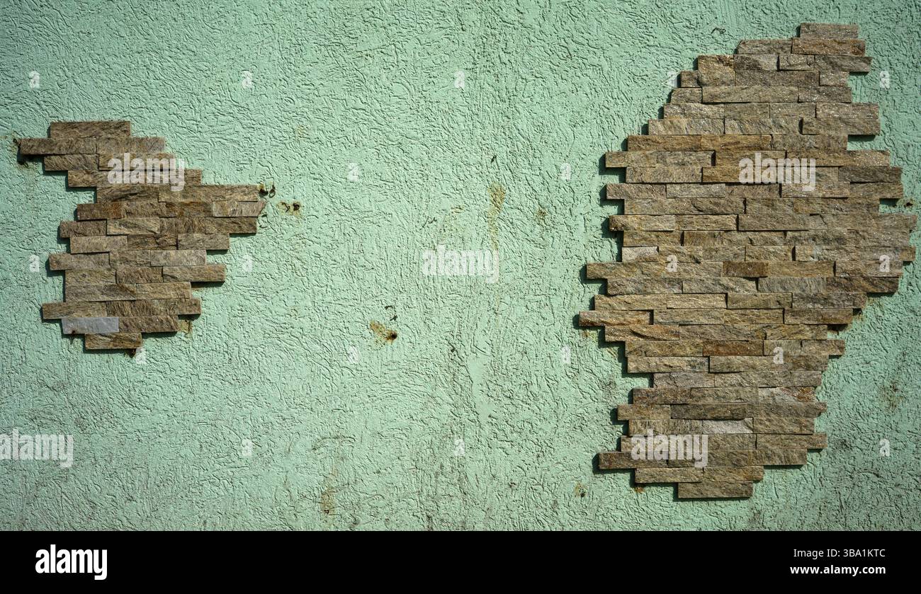 Dekorativer Fassadenziegel an einer hellgrünen Wand, abstrakte Konstruktion. Stockfoto