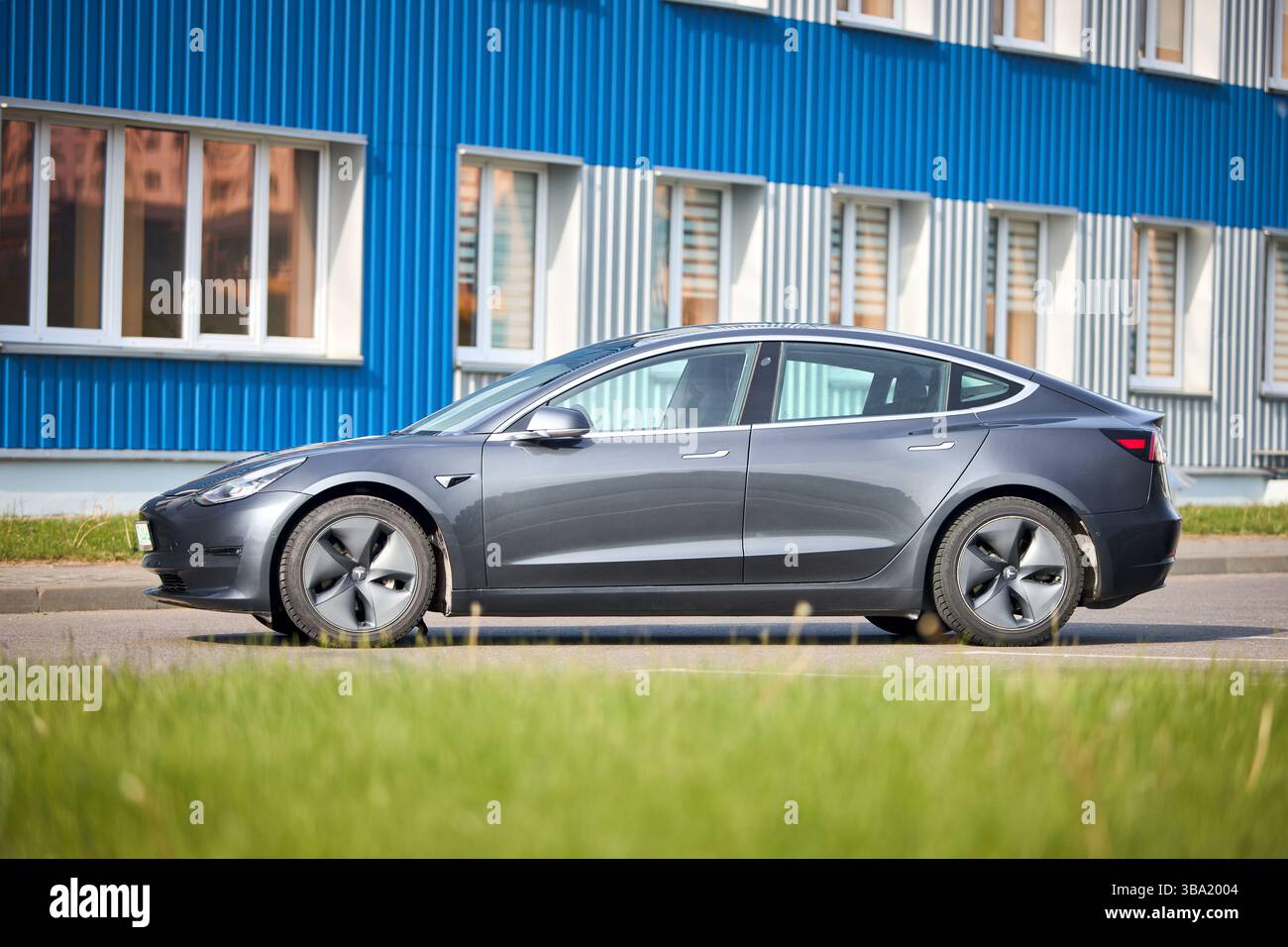 Berlin, 4. Mai 2024: Tesla Model 3 54 kWh Standard Range Plus 2019 selektiver Fokus über außerfokussiertem urbanem Hintergrund. Tesla Model 3 Batterie Stockfoto