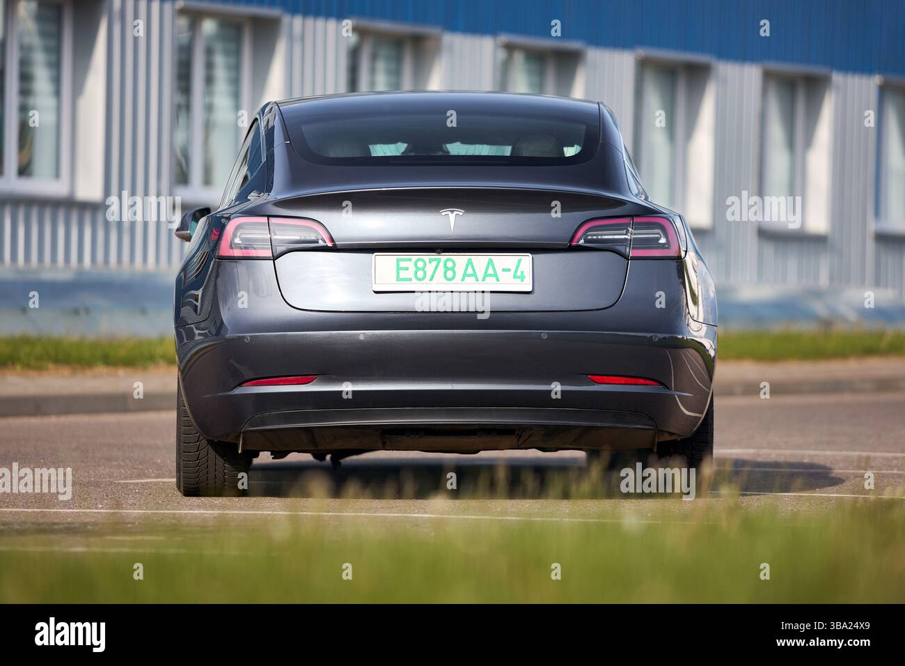Berlin, 4. Mai 2024: Tesla Model 3 54 kWh Standard Range Plus 2019 selektiver Fokus über außerfokussiertem urbanem Hintergrund. Tesla Model 3 Batterie Stockfoto