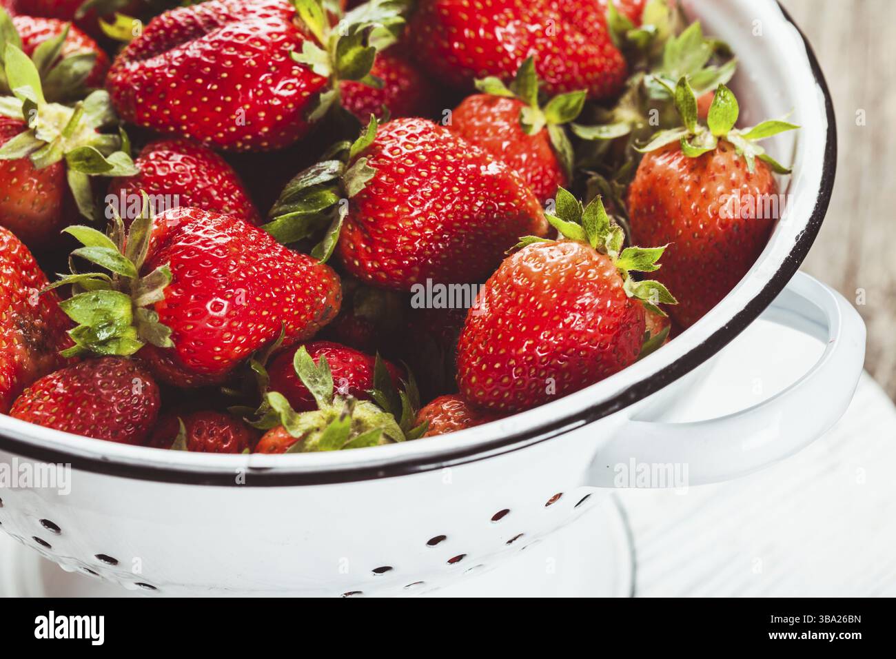 Nahaufnahme Erdbeeren in weißem Vintage-Sieb Stockfoto