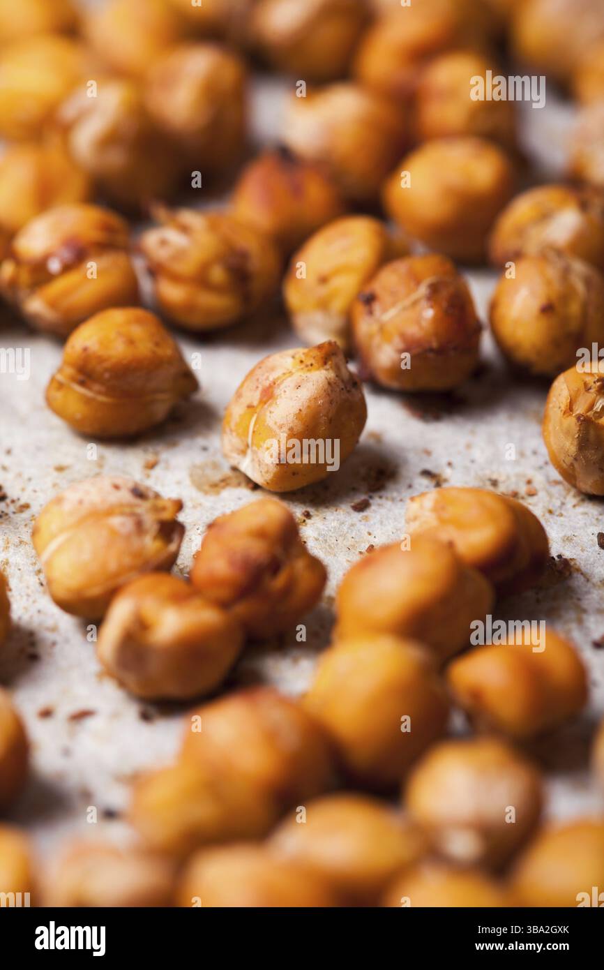 Scharfe gebackene Kichererbsen auf Backpapier verstreut Stockfoto