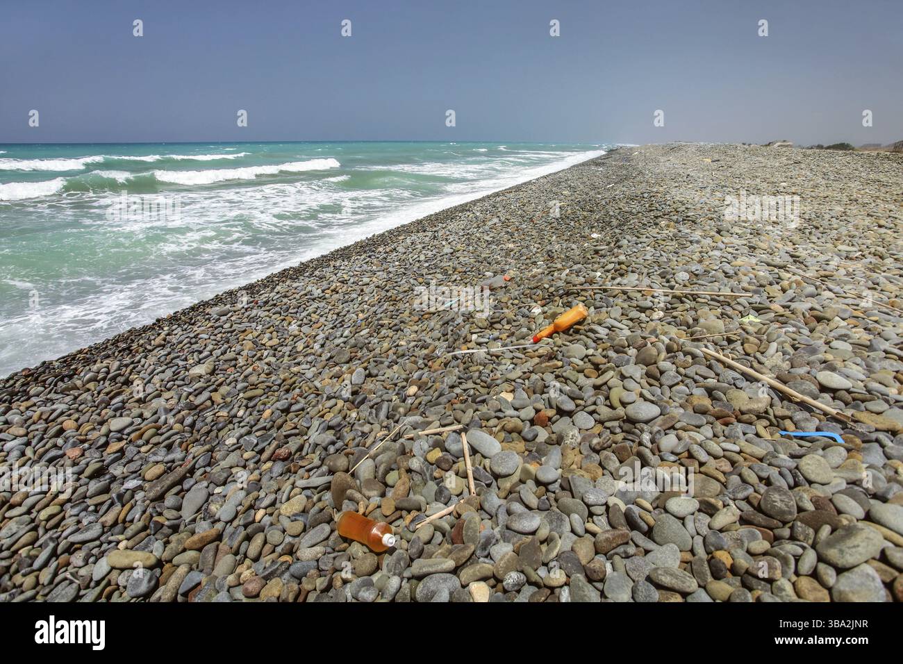 Verschiedene Plastikmüll auf wildem unberührten schwarzen Kieselsteinstrand, wunderschönes Meer im Hintergrund, Denizli, Zypern, Europa Stockfoto