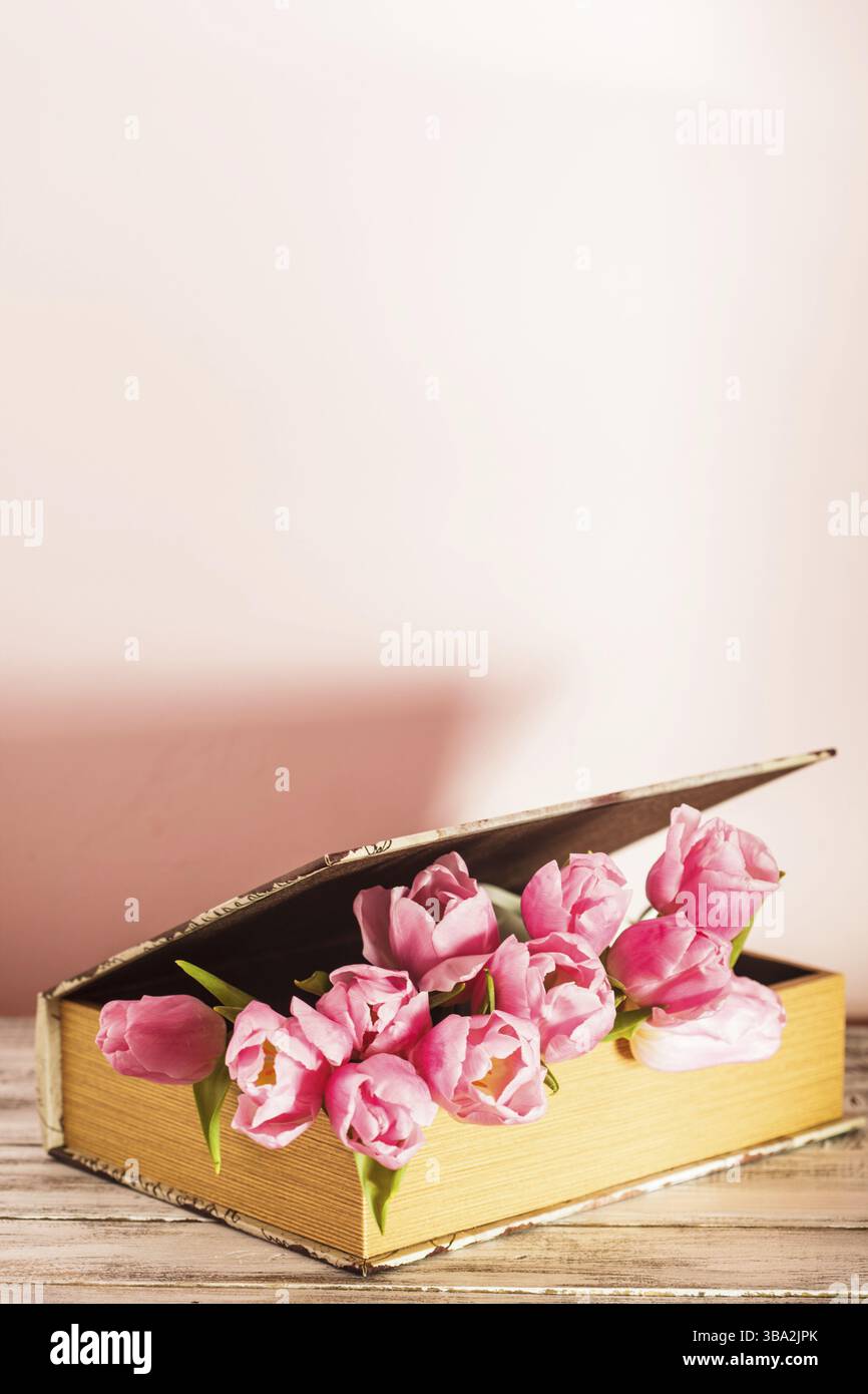 Shabby chic Deko - rosa Tulpen in Vintage Buch Stockfoto
