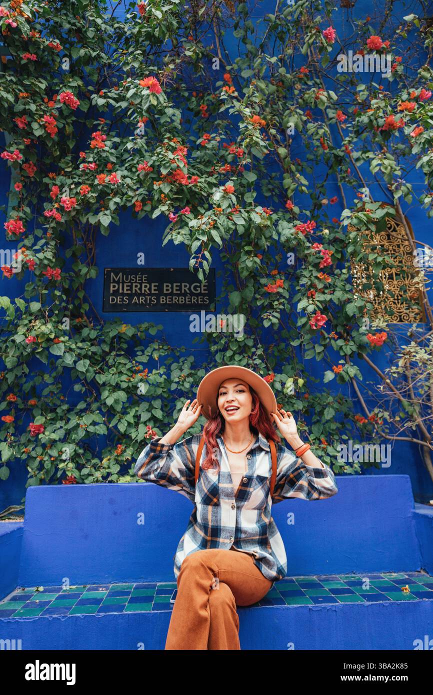 8. März 2025, Marrakesch, Marokko: Junge Frau, die ihren stilvollen Hut anzieht, während sie einen Besuch im Berber-Museum im lebhaften Majorelle-Garten genießt. Stockfoto
