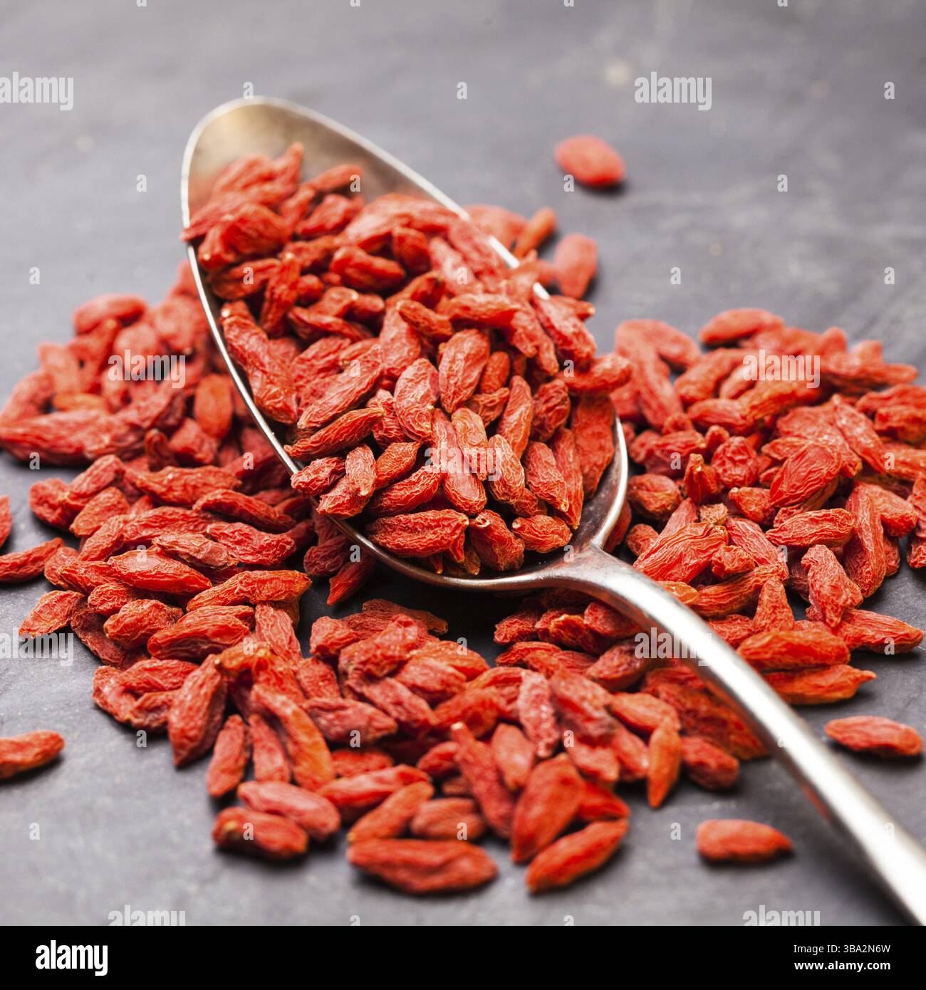 Esslöffel roter getrockneter Goji-Beeren auf dunklem Hintergrund Stockfoto