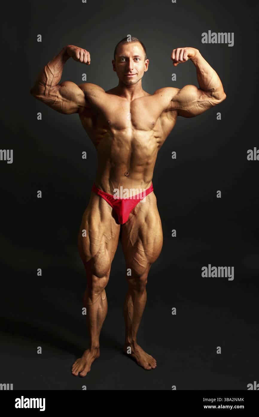 Männlicher Bodybuilder posiert, zeigt die Muskeln des vorderen Körpers, Studio-Aufnahme auf schwarzem Hintergrund Stockfoto