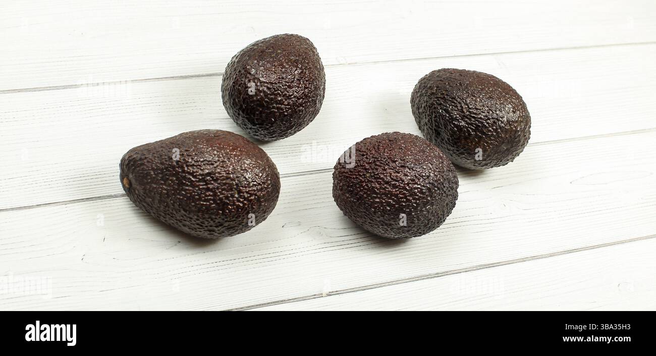 Vier braune, reife Avocados auf weißen Tafeln, Liptovsky Hradok, Slowakei, Europa Stockfoto