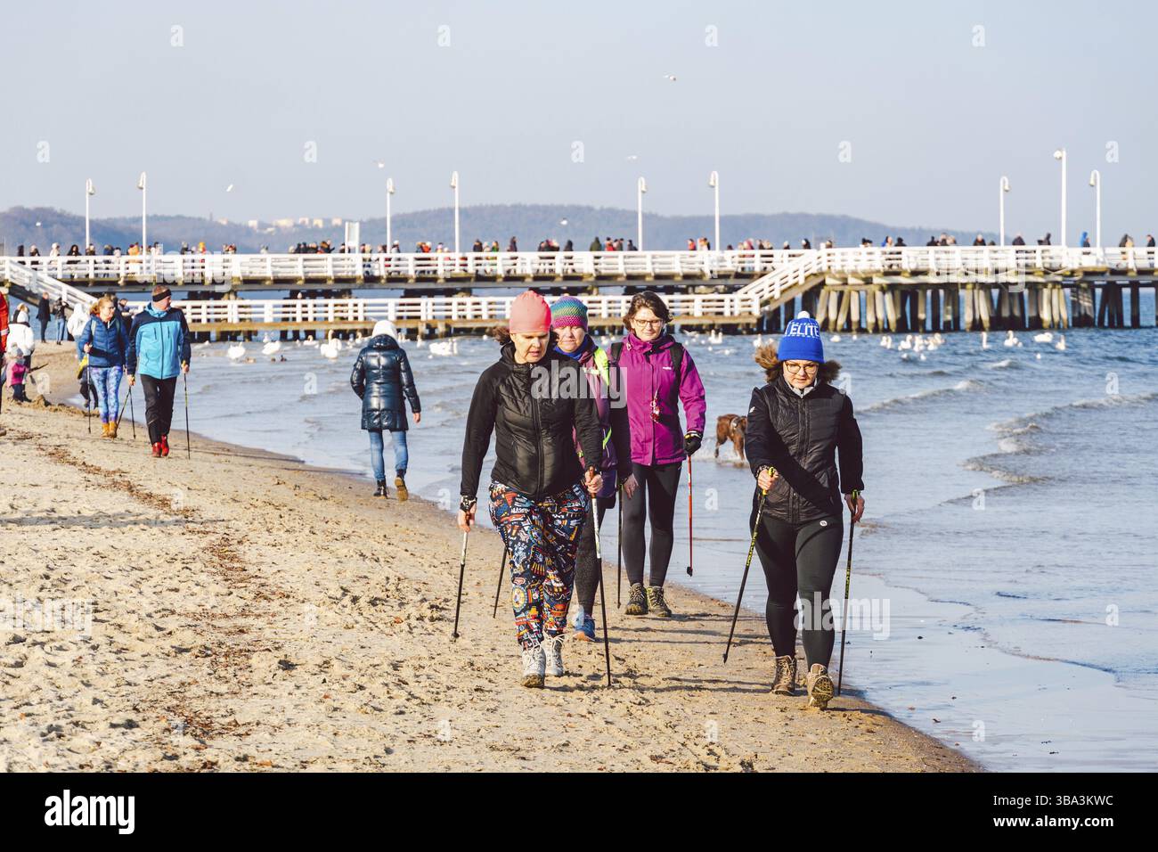 Polen, Sopot, 9. Februar 2020. Leute, die am kalten Strand joggen. Nordic Walking. Wintersaison am Meer. Winterspaziergang am Strand. Die Leute entspannen sich in Col Stockfoto
