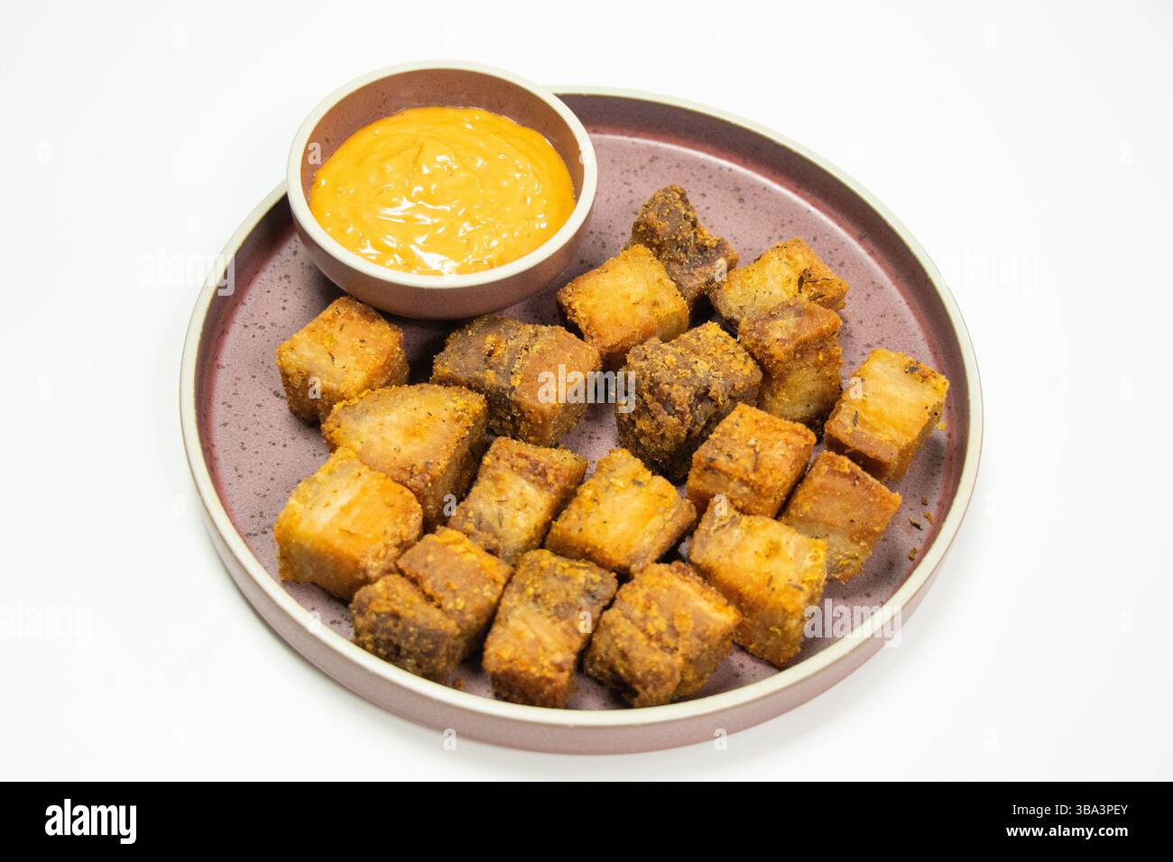 Knusprig gebratene Schweinebauchbacken und scharfe Sauce mit weißem Hintergrund Stockfoto