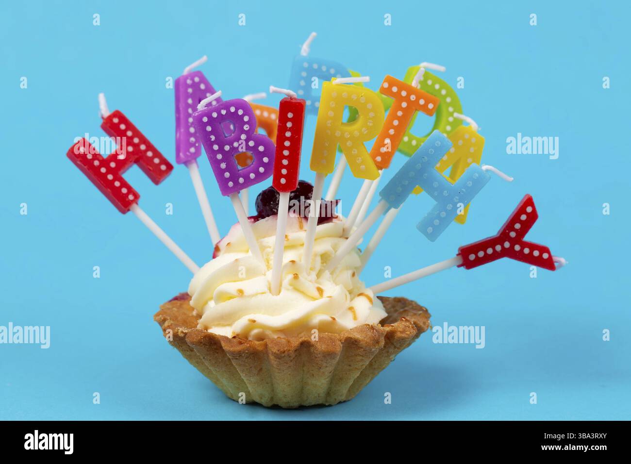 Cupcake mit regenbogenfarbenen Kerzen zum Geburtstag mit der Inschrift Happy birthday Stockfoto