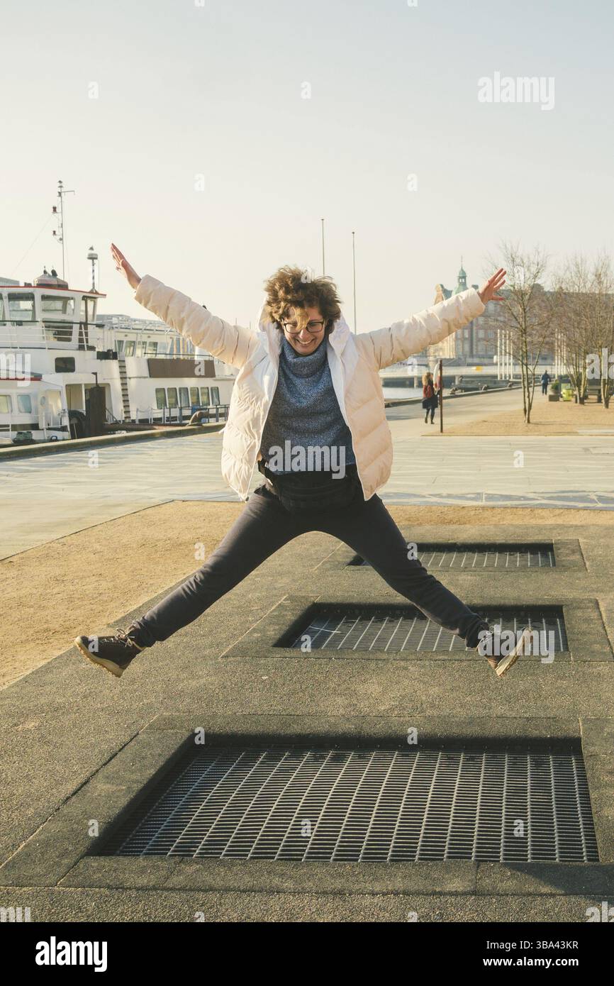 Erwachsener freut sich wie ein Kind. Spielplatz Trampolin im Boden, Kinder-Trampolin, Federn wecken die Leute Spaß und cool. Kopenhagen Fluss Embank Stockfoto