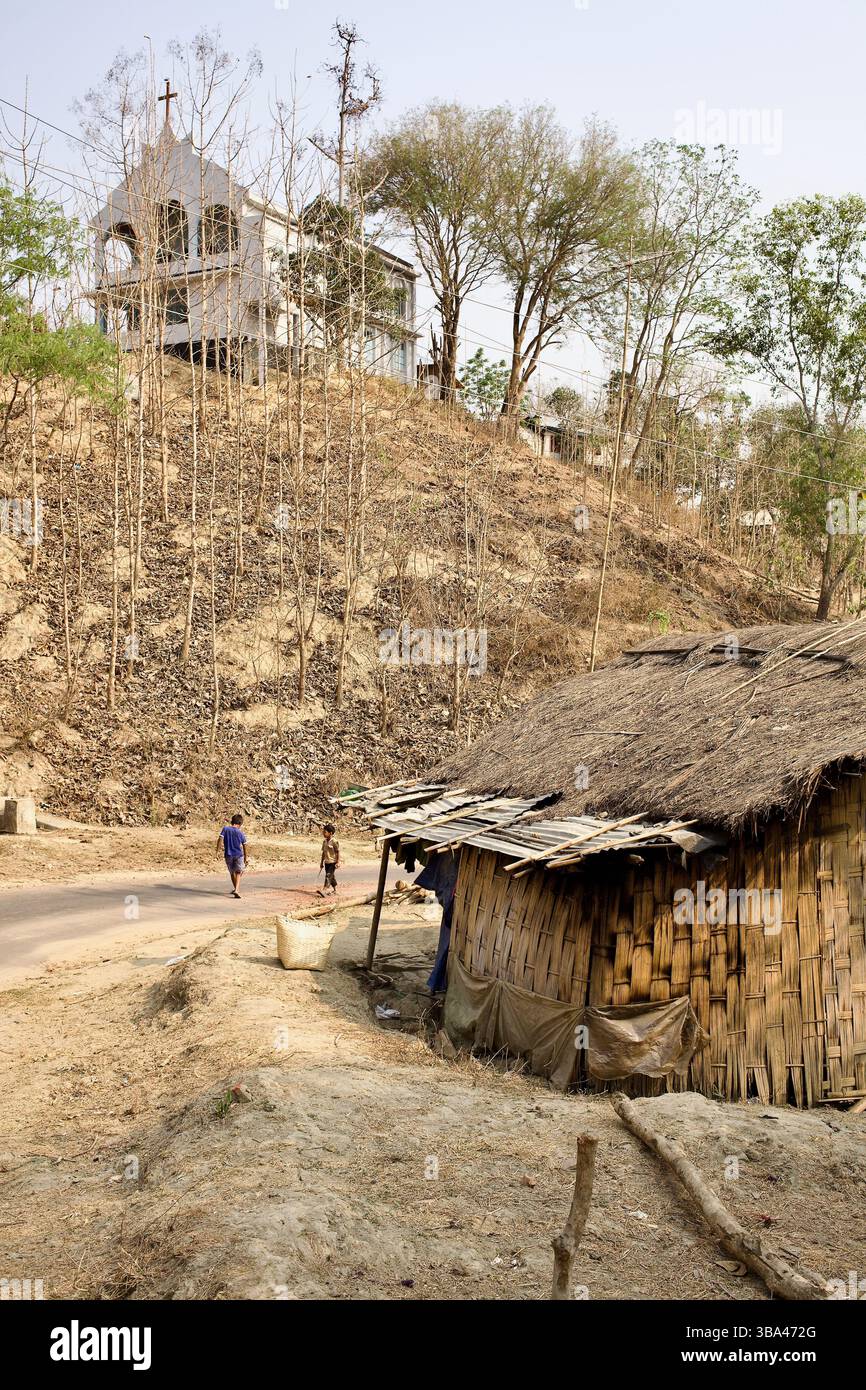 Das Haus mit Strohdach unter einer Kirche auf einem Hügel in Laimi Para, Bandarban, verfolgt Glauben, Überleben und koloniale Vermächtnisse in einer marginalisierten indigenen Siedlung. Stockfoto