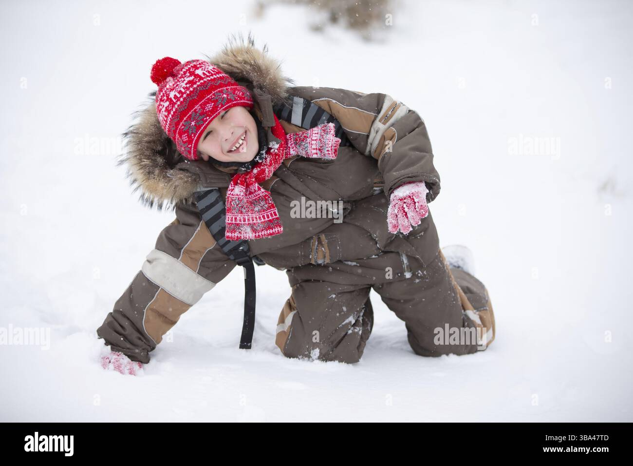 Lustiger Junge im Winter geht mit einem Rucksack zur Schule Stockfoto