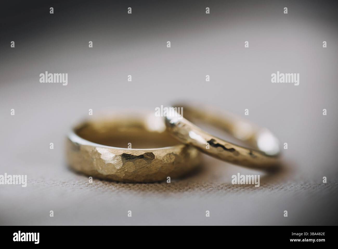 Hochzeitsgoldringe liegen auf neutralem Hintergrund. Hochzeitsdetails und -Dekoration, Kopierraum Stockfoto