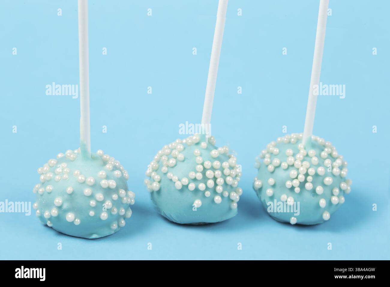 Bonbons auf Stöcken. Blaue Kuchen auf blauem Hintergrund.schönes süßes Dessert Stockfoto