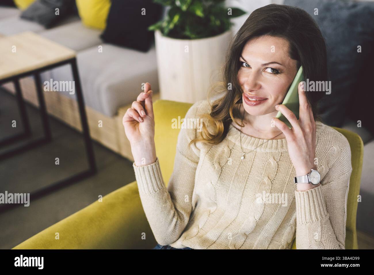 Glückliche, erfolgreiche Geschäftsfrau, die mit dem Handy anruft, während sie im Café sitzt, lächelnde Unternehmerin, die einen Laptop benutzt und mit ihr gesprochen hat Stockfoto