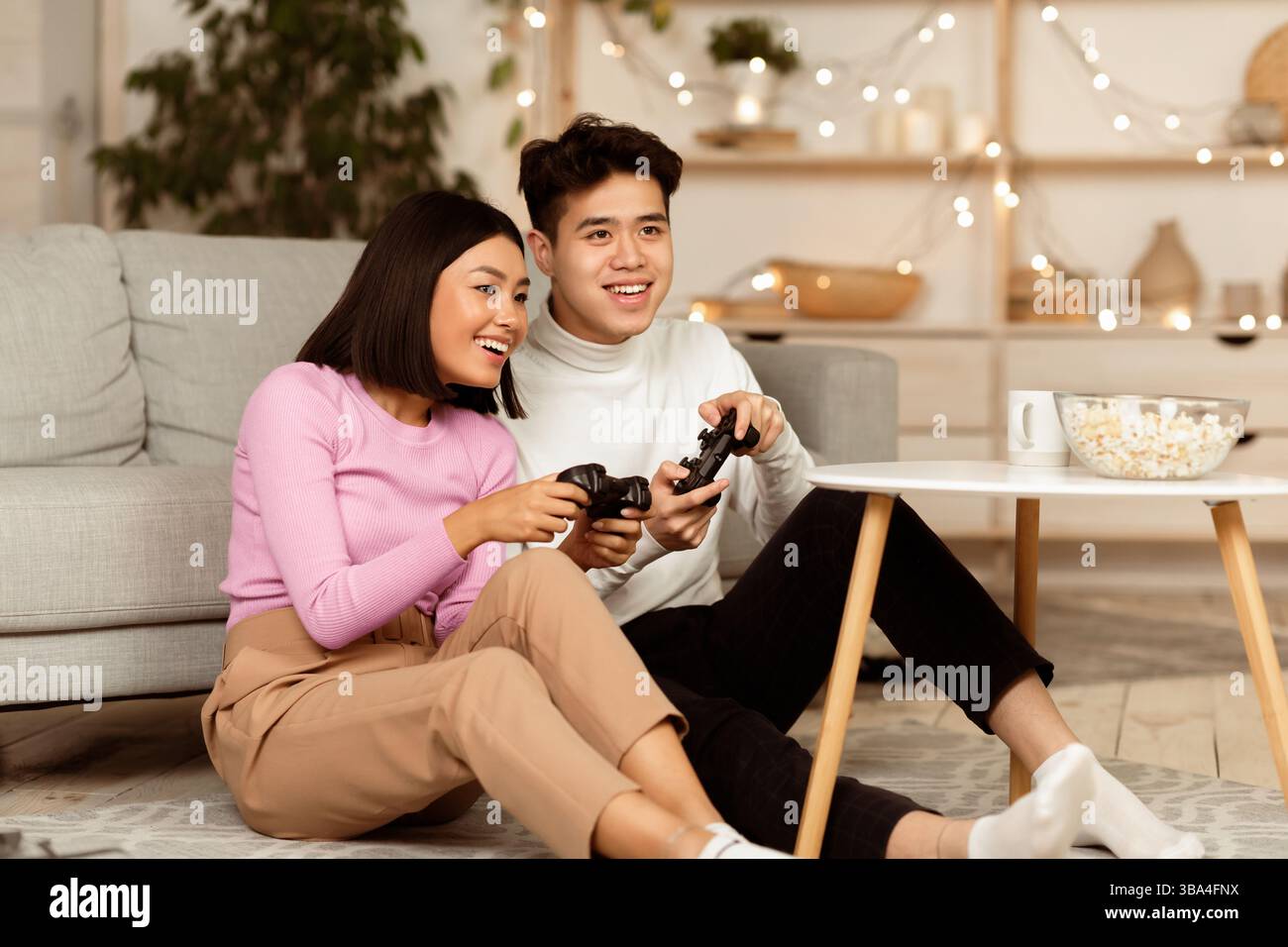 Chinesische Freundin Und Freund Spielen Videogame Bei Zu Hause Stockfoto