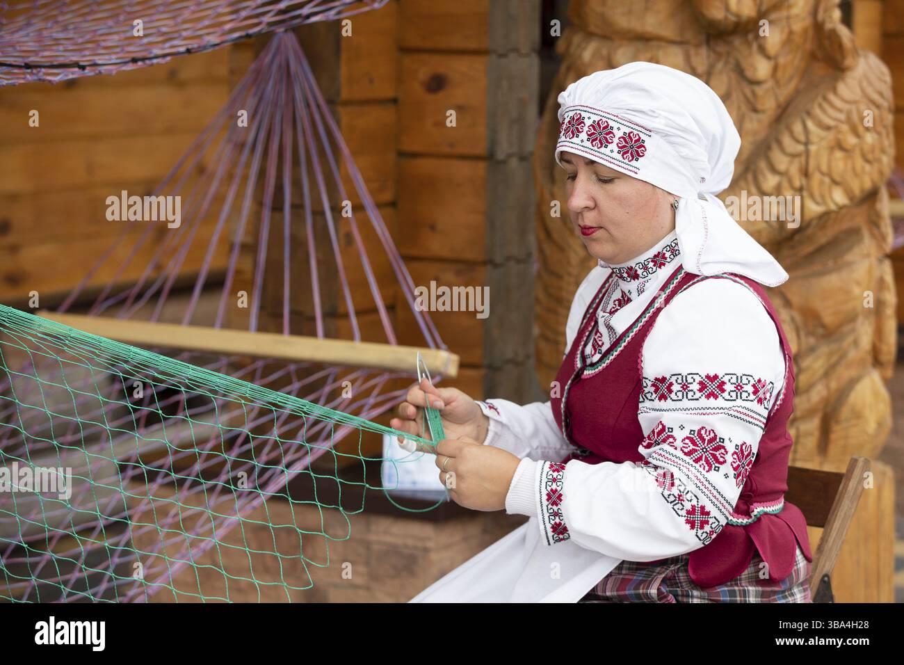 20. August 2022. Belarus, das Dorf Lyaskovichi. Feiertag der belarussischen Kultur. Die slawische belarussische Frau in Nationalkleidung engagiert sich in Traditio Stockfoto