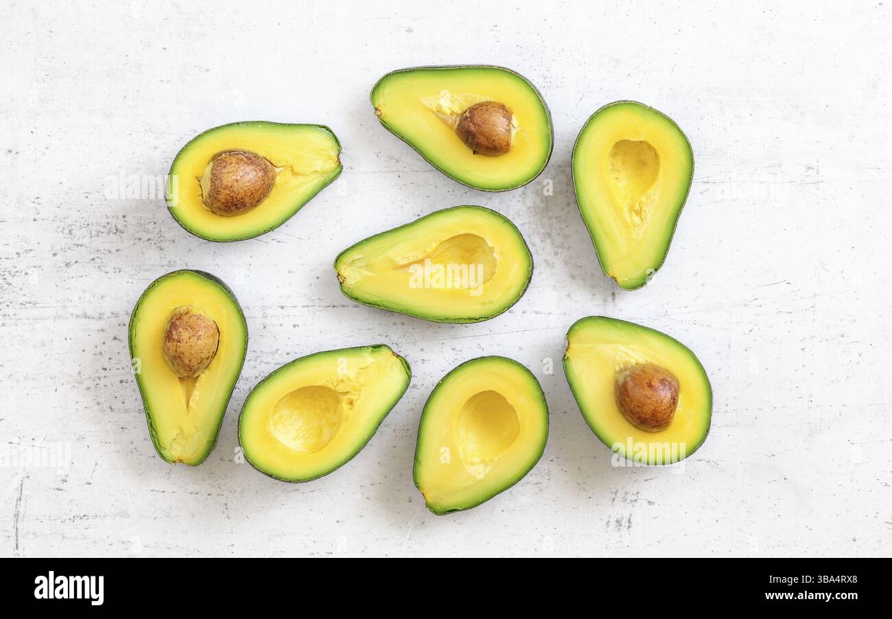 Avocadohälften, einige mit Samen auf weißem Brett, flache Ansicht, Liptovsky Hradok, Slowakei, Europa Stockfoto