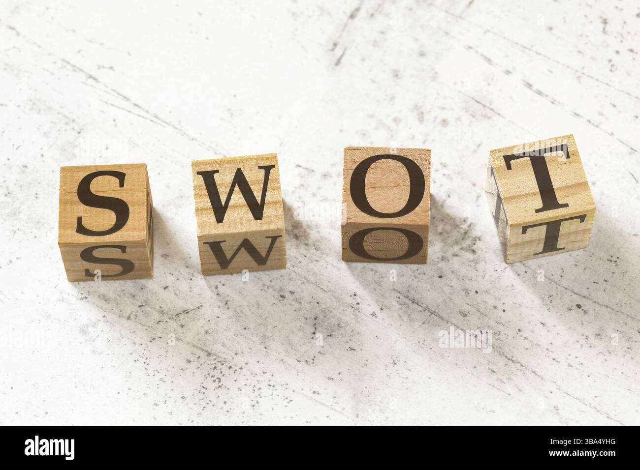 Vier Holzwürfel mit den Buchstaben SWOT (was Stärke, Schwäche, Chance und Bedrohungsanalyse bedeutet) auf weißem Arbeitsbrett, Liptovsky Hradok, Slowakei Stockfoto
