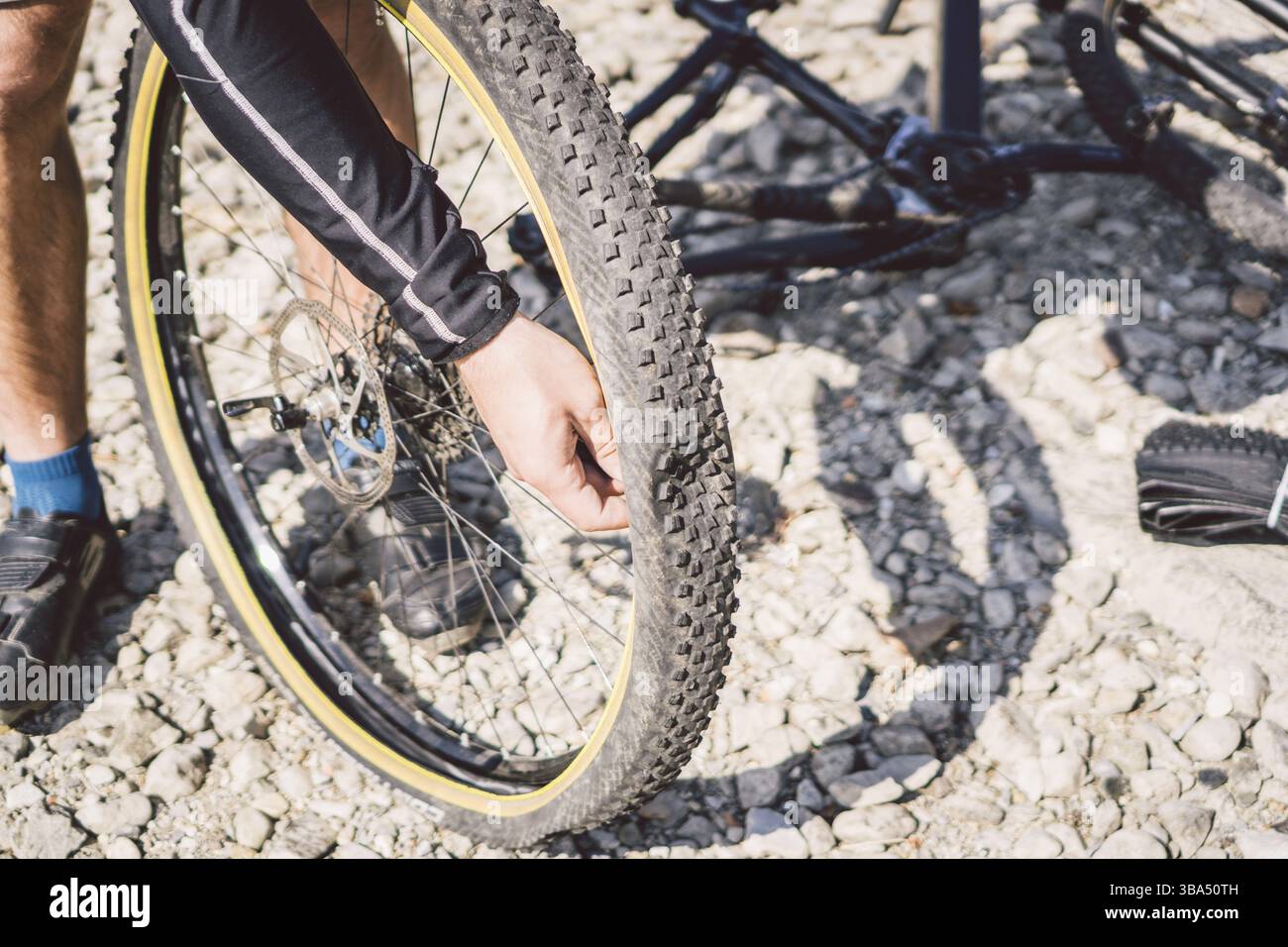 Fahrradreparatur. Mann Repariert Mountainbikes. Radfahrer in Not Hinterrad Unfallfall. Man repariert das Fahrrad in der Nähe des Sees in Italien Stockfoto