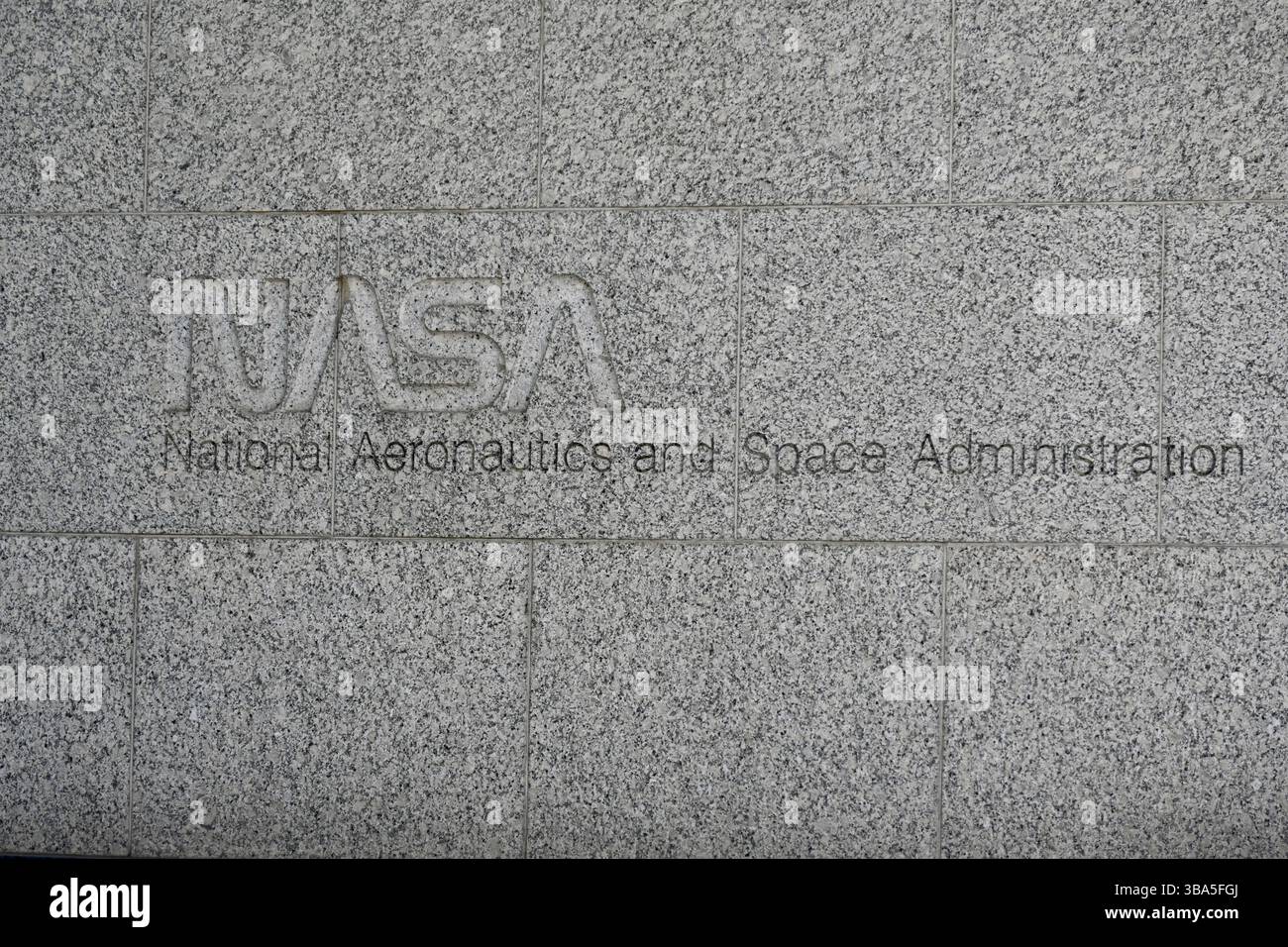 Washington, D.C., USA – 10. Mai 2025: Das NASA-Wurmlogo und die Worte „National Aeronautics and Space Administration“ sind in eine Steinmauer eingeätzt. Stockfoto