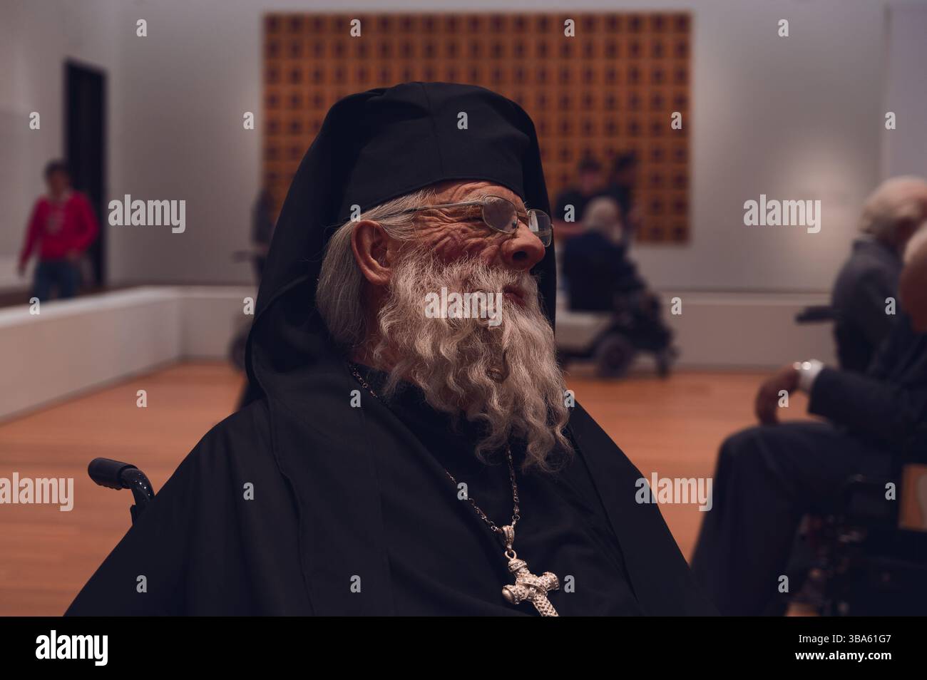 Lebensechte Skulptur eines älteren Ordensmannes mit großem Kreuz in der Kunstinstallation "Old Persons Home" Stockfoto