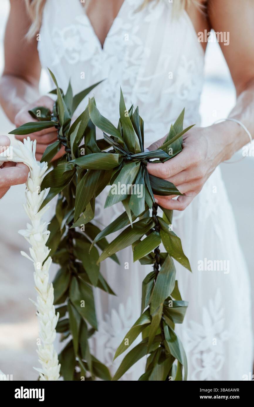 Jungvermählte halten hawaiianische Lei in Beach Elopement Stockfoto